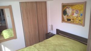 1 dormitorio con 1 cama y una pintura en la pared en Gereben Apartman Pécs, en Pécs