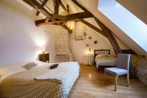 Schlafzimmer im Dachgeschoss mit 2 Betten und einem Stuhl in der Unterkunft Manoir de la Blonnerie in Vellèches