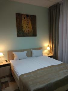 een slaapkamer met een bed met 2 lampen en een schilderij bij Mini Hotel Konstantinych in Kislovodsk