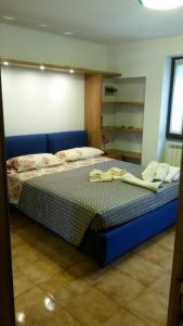 een slaapkamer met een blauw bed in een kamer bij Casa vacanze Dalia in Marone