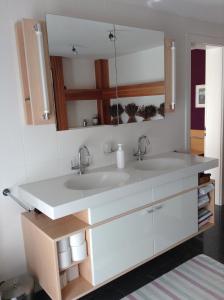 Baño con 2 lavabos y espejo en BnB Chantevent, en Sierre