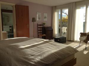 Un dormitorio con una cama grande y una ventana en BnB Chantevent en Sierre