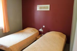 twee bedden in een kamer met rode muren bij Lou Daro in Cébazan
