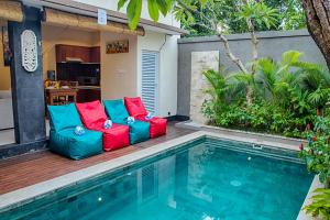 a patio with colorful furniture next to a swimming pool at Villa Sedana in Seminyak