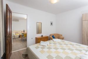ein Schlafzimmer mit einem Bett mit einer karierten Decke in der Unterkunft Apartment Family Tokic in Dubrovnik
