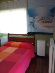 Apartment Elena في بيرايوس: غرفة نوم مع سرير وبطانية ملونة