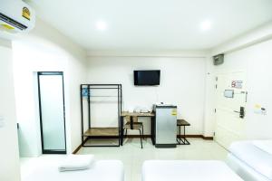 a white room with a table and a tv at Don Muang Hotel in Bangkok