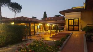 una casa con patio arredato con tavoli e sedie di Hotel Duca Della Corgna a Castiglione del Lago