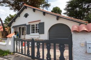 een hondenhok met een hek en een hek bij Proche plage et marché, grand jardin, barbecue 9 pers in La Baule