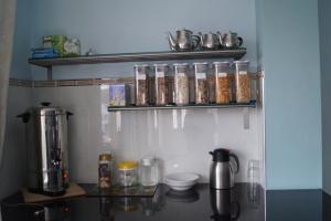 a kitchen with a counter with a coffee maker on a shelf at Marie's Bed and Breakfast in Coolock