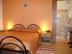 a bedroom with a bed and a bathroom with a sink at Hotel Spampatti in Castione della Presolana