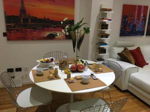 sala de estar con mesa blanca y sillas en Flowers Apartment, en Bari