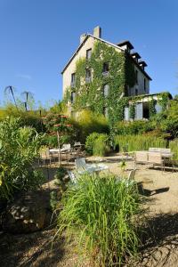 un bâtiment recouvert de lierre avec des tables et des chaises dans l'établissement Ty Mad, à Douarnenez