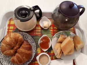 三河市Gites Chez Marie Christine的茶几,茶壶和一盘面包