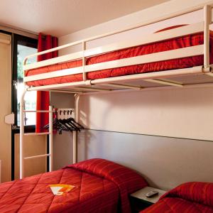 a bed room with two red beds and a red wall at Première Classe Tarbes - Bastillac in Tarbes