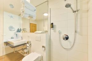 ein Badezimmer mit Dusche, Toilette und Waschbecken in der Unterkunft Alpen Deluxe Oberammergau in Oberammergau + 36 Fotos