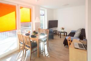 een woonkamer met een tafel en stoelen en een bank bij Apartment11 Wartburg in Keulen