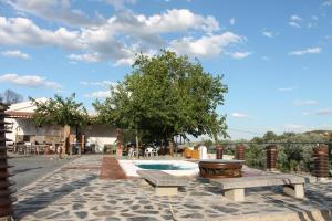 a patio with two benches and a swimming pool at Alojamiento rural El Salto in Villafranca de Córdoba