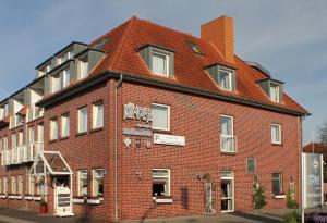 ein großes rotes Backsteingebäude mit spitzem Dach in der Unterkunft Hotel-Restaurant Kämper Superior in Bad Zwischenahn