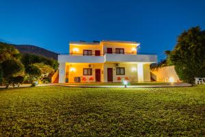 a large house with a lawn in front of it at Angela Studios Pefkos in Pefki