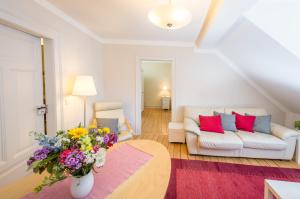 a living room with a couch and a vase of flowers at "goethezimmer" an der Herderkirche in Weimar