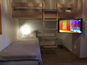 Belle Plagne Premium في بيل بلاني: غرفة نوم مع سرير بطابقين وتلفزيون بشاشة مسطحة