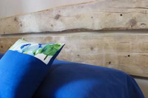 a blue pillow sitting on a bed with a wooden wall at A Baracca du Pei in Imperia
