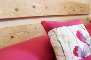 インペリアにあるA Baracca du Peiの木製の壁の赤いソファに枕