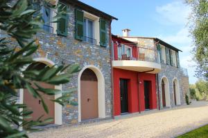 a brick building with red doors and a balcony at A Baracca du Pei in Imperia