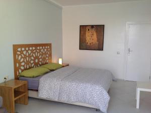 1 dormitorio con 1 cama y una foto en la pared en Wind House en Imsouane