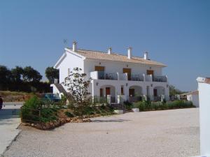 a large white house on the side of a road at Apartamentos el Volapie in Montemayor