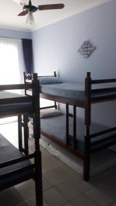 two beds in a room with a ceiling fan at Apartamento no Varandas de Itaguá in Ubatuba