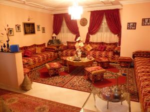 マラケシュにあるChez Axia Marrakechのリビングルーム(赤いソファ、テーブル付)