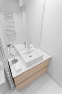 グダニスクにあるVIU Light Apartmentのバスルーム(白い洗面台、鏡付)