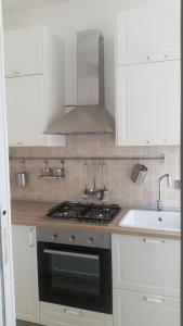 uma cozinha branca com um fogão e um lavatório em La Casa del Sire em Marino