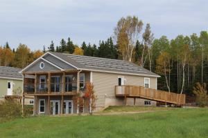 a house with a porch and a deck at Cape Breton Villas in Inverness