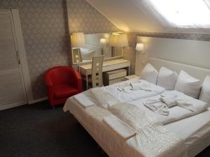 a bedroom with a bed and a desk with a red chair at Motelik Lord in Gorzów Wielkopolski