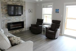 
a living room filled with furniture and a fireplace at Cape Breton Villas in Inverness
