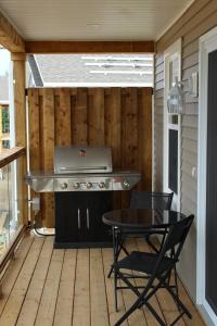 a screened in porch with a grill and a table at Cape Breton Villas in Inverness