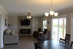 a dining room and living room with a table and a fireplace at Cape Breton Villas in Inverness