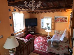 a living room with a couch and a tv at Storico Loft nel Cuore di Lucca in Lucca