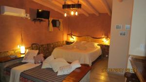 una camera con due letti e un divano in camera di Cabañas Entre Verde a Los Hornillos