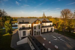 eine Luftansicht eines Hauses mit großem Parkplatz in der Unterkunft Kasor Resort & Spa in Stryków