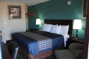um quarto de hotel com uma cama e duas cadeiras em Budget Inn em Alamogordo