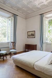 a white bedroom with a bed and two windows at Classic Hotel in Florence