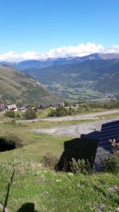 uma vista para um campo com montanhas à distância em studio saint lary soulan em Saint-Lary-Soulan