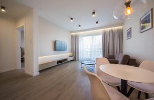 a living room with a table and chairs at Mariacka Old Town Apartments in Szczecin