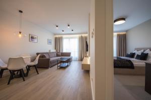 a living room with a bed and a couch and a table at Mariacka Old Town Apartments in Szczecin