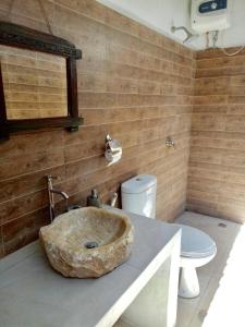 Un baño con un gran lavabo de piedra sobre una encimera. en Melati Bali Homestay, en Canggu 24 fotos más