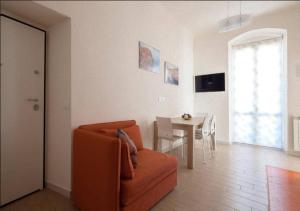 un soggiorno con divano arancione e tavolo di Glad Apartment a La Spezia
